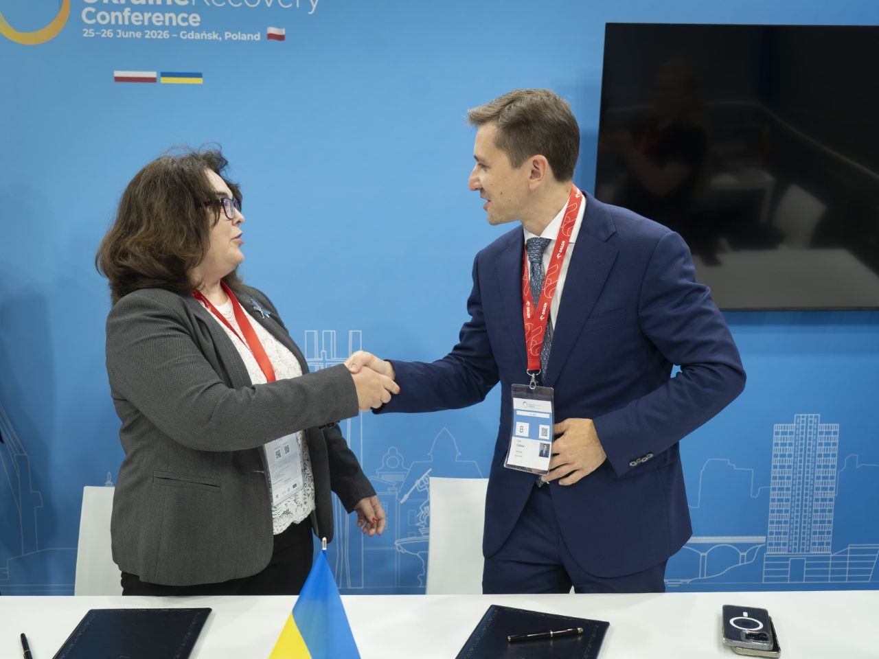 Representatives from the BSTDB and Metinvest shake hands after signing a cooperation agreement at the Ukraine Recovery Conference 2026 in Gdańsk, Poland